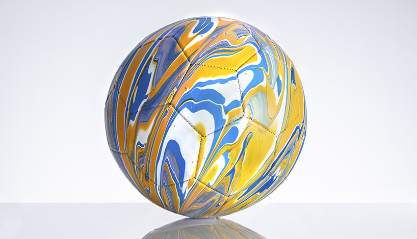 fusion paint-pouring turns national football strips into colorful marbled balls 