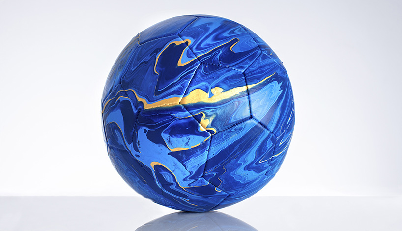 fusion paint-pouring turns national football strips into colorful marbled balls 