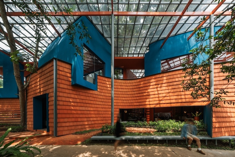 azure blue hues contrast with terracotta tiles on nusa kitchen pavilion's facade in java