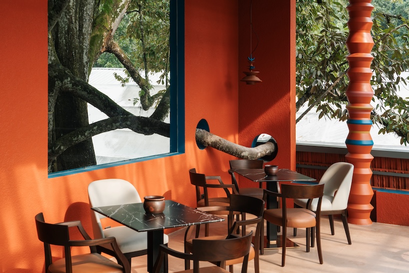 azure blue hues contrast with terracotta tiles on nusa kitchen pavilion's facade in java