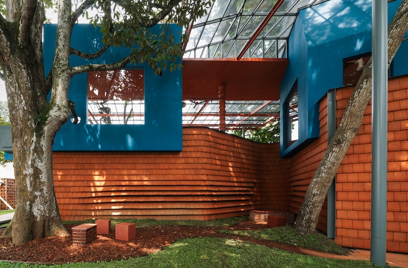 azure blue hues contrast with terracotta tiles on nusa kitchen pavilion's facade in java