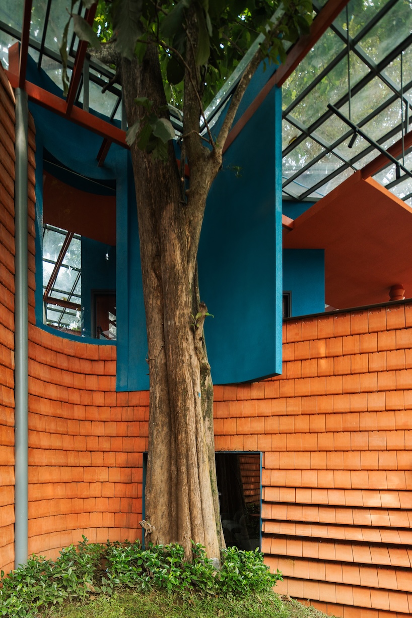 azure blue hues contrast with terracotta tiles on nusa kitchen pavilion's facade in java