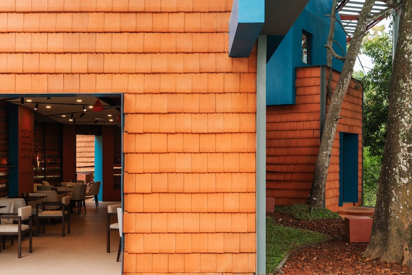 azure blue hues contrast with terracotta tiles on nusa kitchen pavilion's facade in java