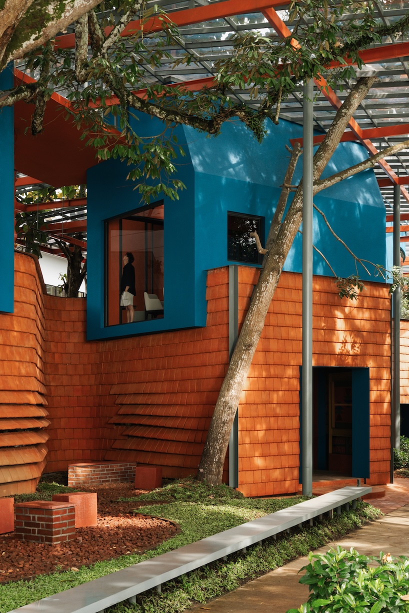 azure blue hues contrast with terracotta tiles on nusa kitchen pavilion's facade in java