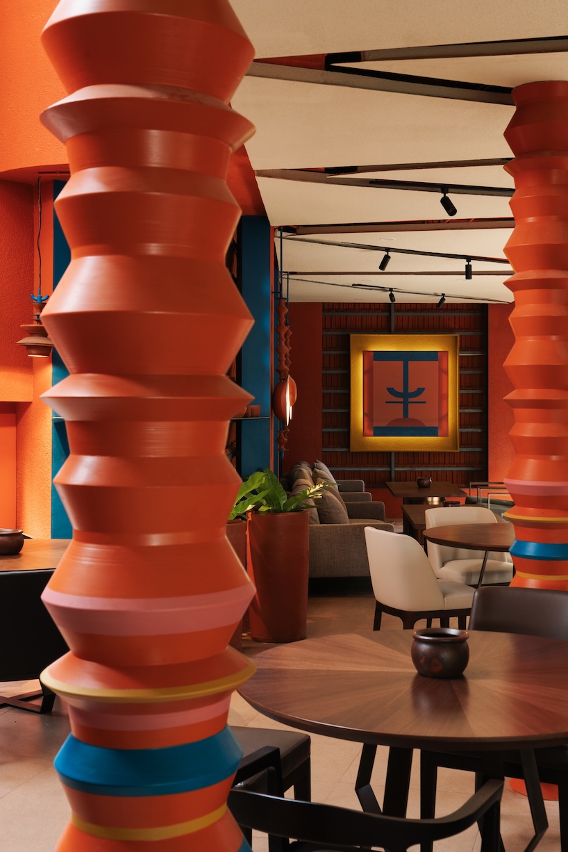 azure blue hues contrast with terracotta tiles on nusa kitchen pavilion's facade in java