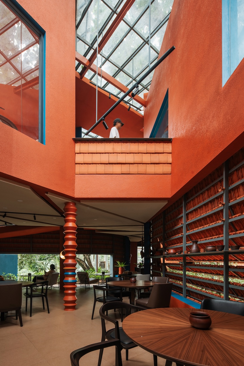azure blue hues contrast with terracotta tiles on nusa kitchen pavilion's facade in java