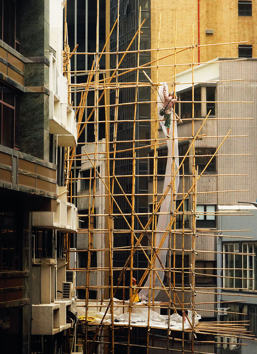 romain jacquet-lagrèze captures bamboo scaffolding workers hovering above hong kong