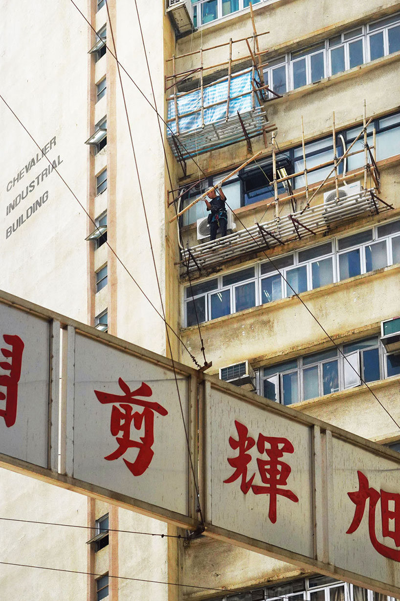 romain jacquet-lagrèze captures bamboo scaffolding workers hovering above hong kong