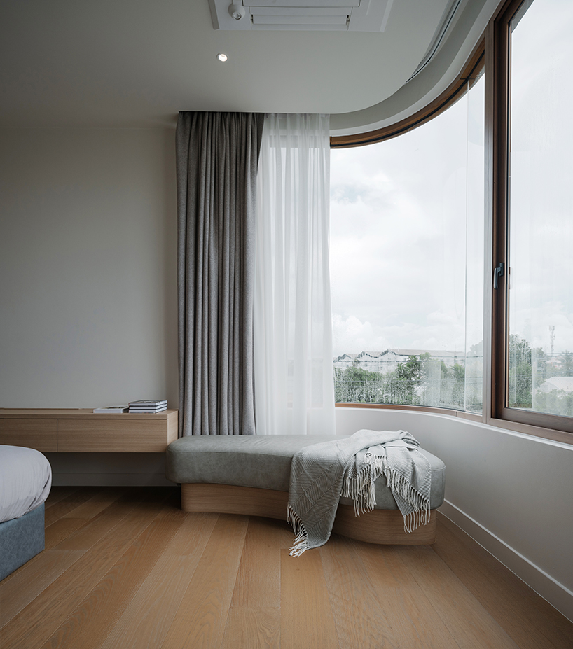 curved concrete volumes interlock through glass hinge to extend oom house in bangkok - 7