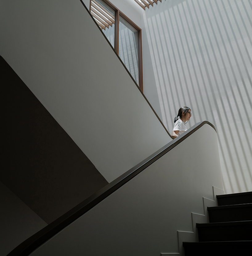 curved concrete volumes interlock through glass hinge to extend oom house in bangkok - 5