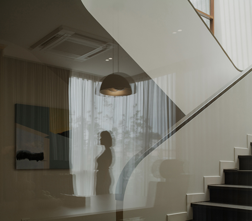 curved concrete volumes interlock through glass hinge to extend oom house in bangkok - 6