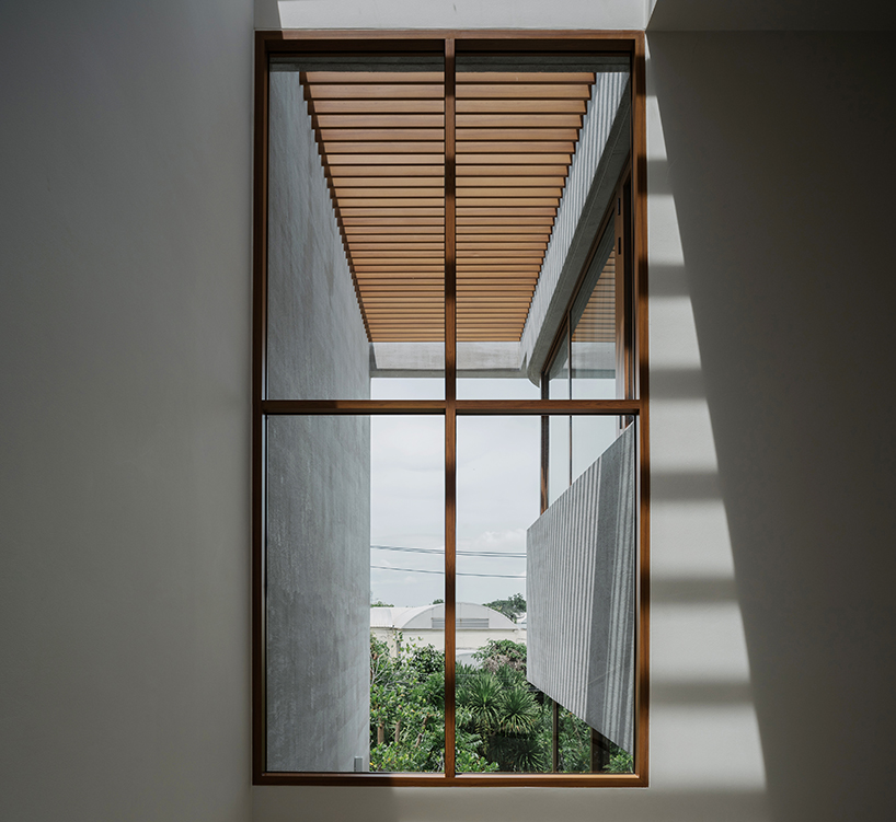 curved concrete volumes interlock through glass hinge to extend oom house in bangkok - 4