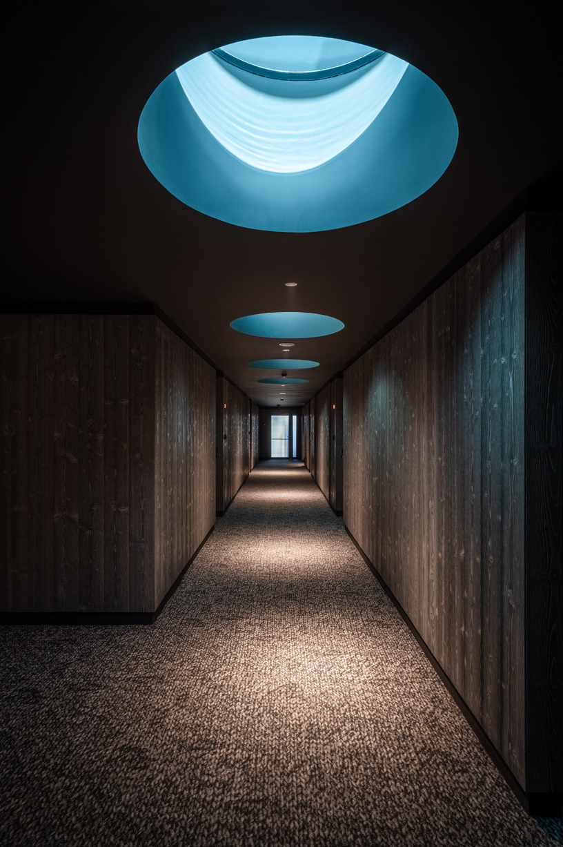 yod group embeds portholes looking into steel pool within hay boutique hotel's corridors