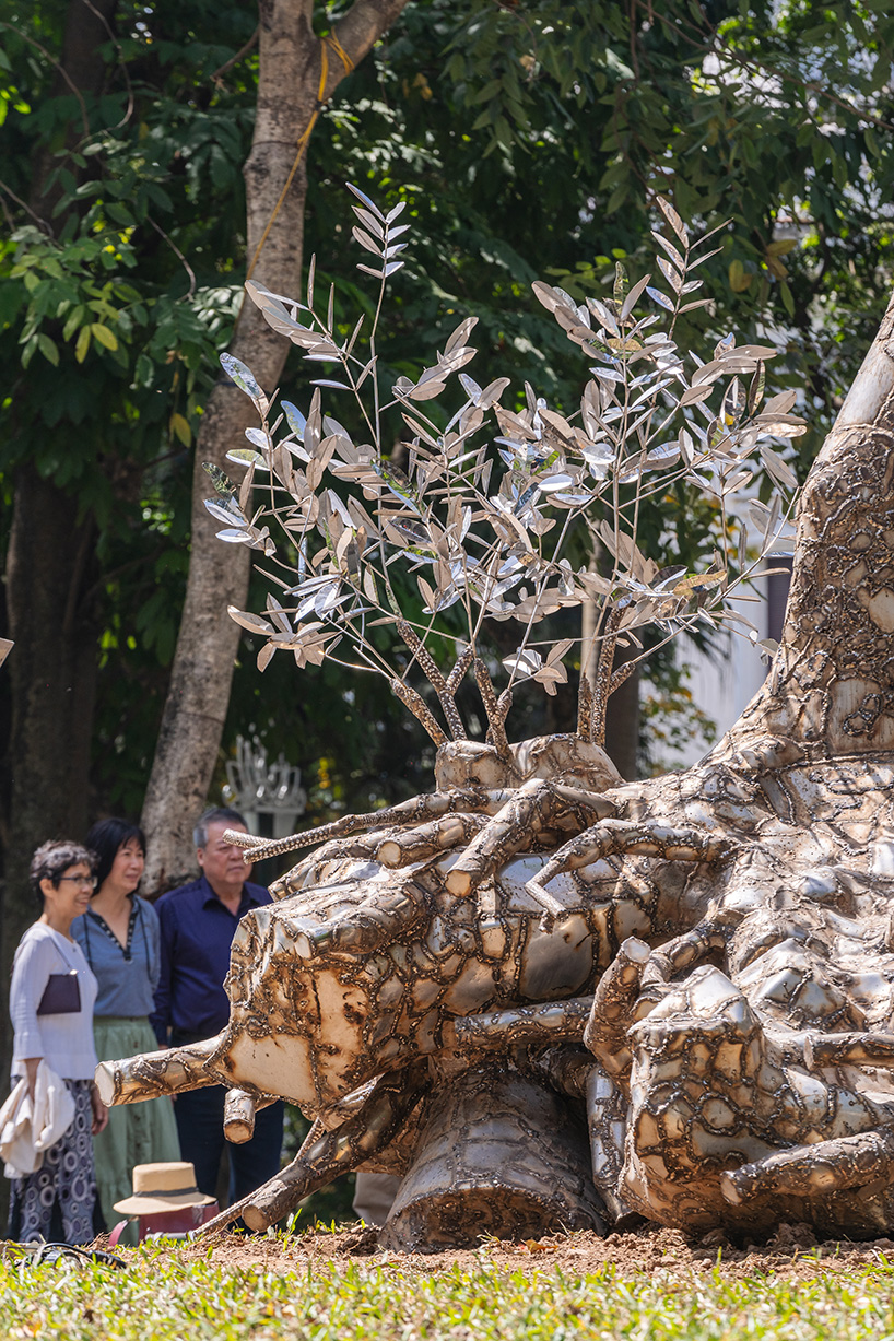 reflective steel skin clads sculpture emerged from fallen tree after typhoon in hanoi