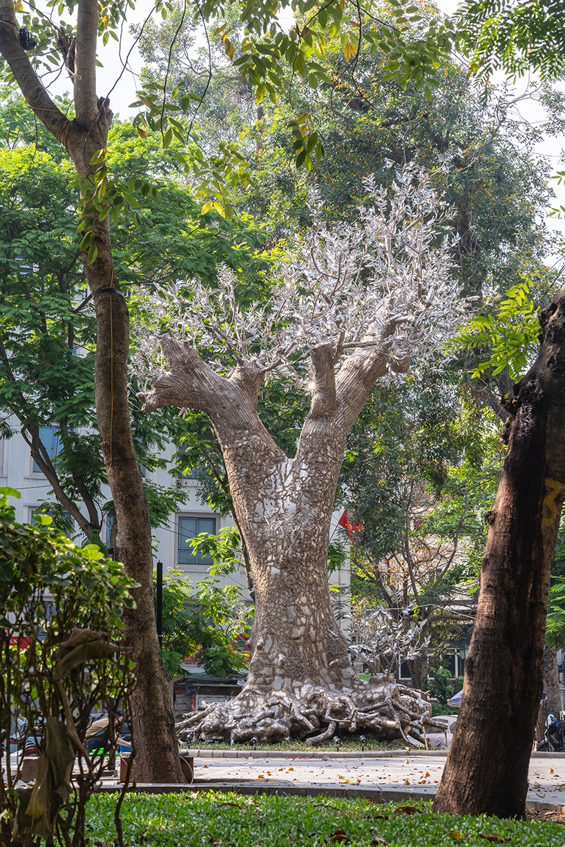 Patung kulit reflektif muncul dari pohon tumbang setelah topan di Hanoi