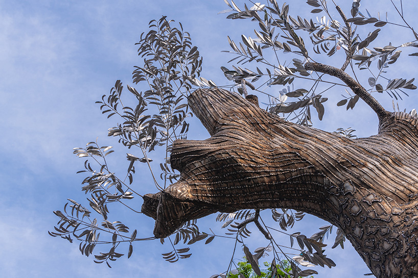 reflective steel skin clads sculpture emerged from fallen tree after typhoon in hanoi