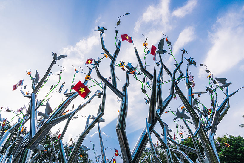 a circle of mirroring steel branches composes a luminous forest in hanoi's public realm