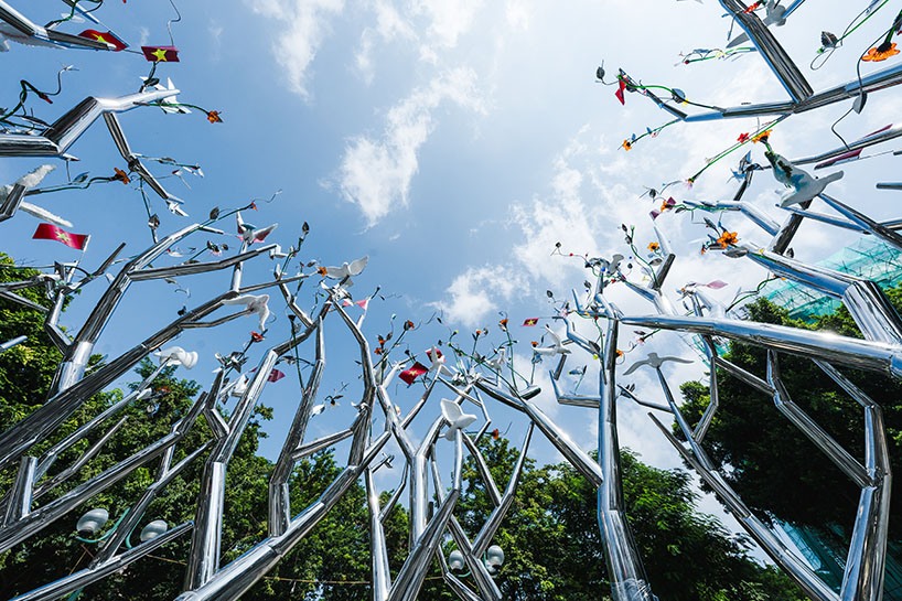 a circle of mirroring steel branches composes a luminous forest in hanoi's public realm