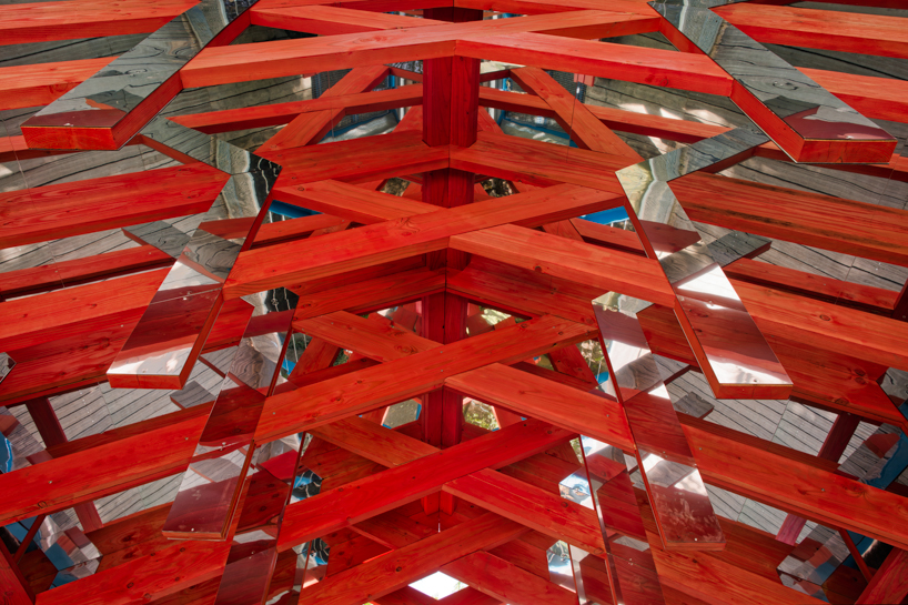 coral-toned timber and mirror canopy by GRRIZ transforms footbridge above river in france