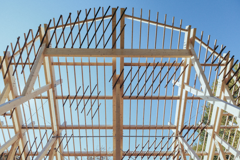 palcosole by grriz raises a half sun of timber above a historic park to gather community and light 7