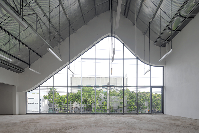 three asymmetrical curved gable roofs top ASWA’s community hub in thailand