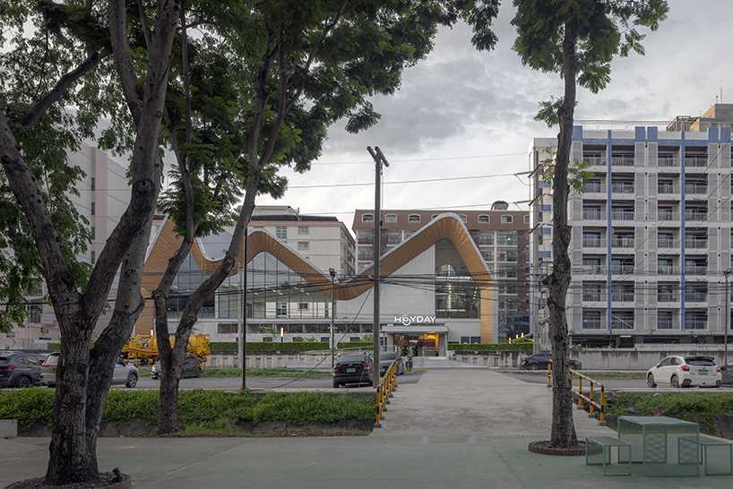 Tres techos a dos aguas curvados asimétricos del Centro Comunitario ASWA en Tailandia