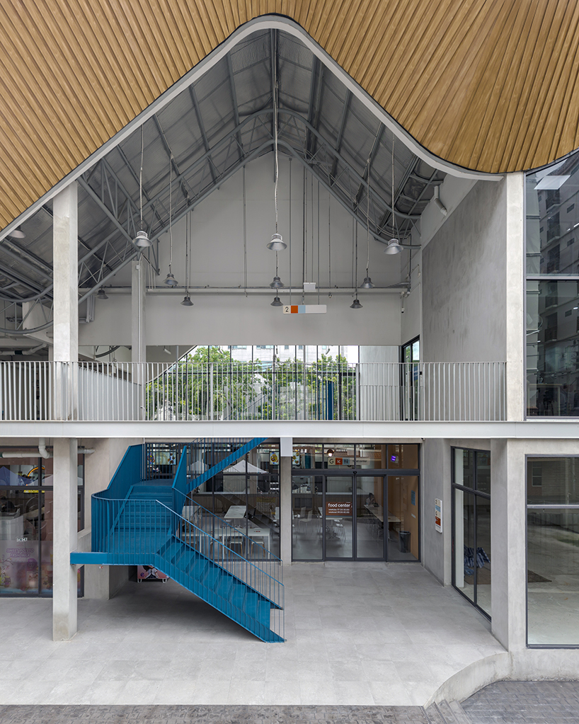 three asymmetrical curved gable roofs top ASWA’s community hub in thailand