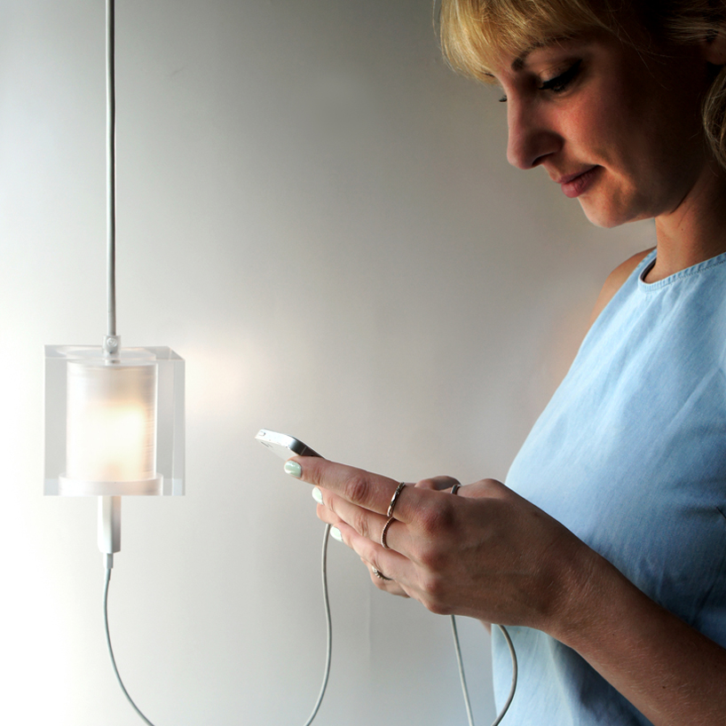 this suspending workspace lamp allows users to charge their devices simultaneously