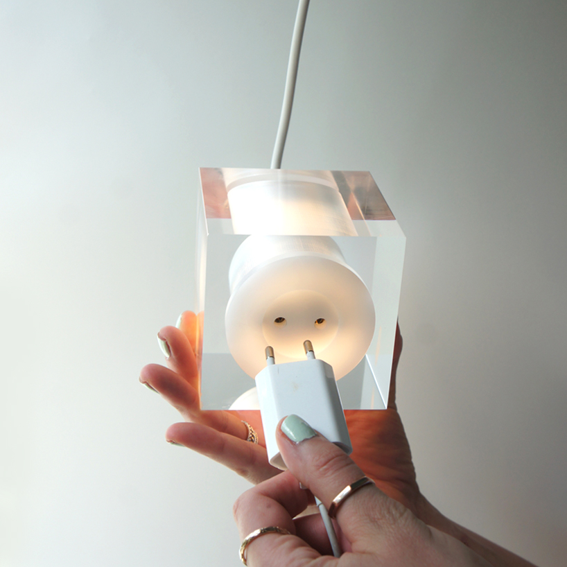 this suspending workspace lamp allows users to charge their devices simultaneously
