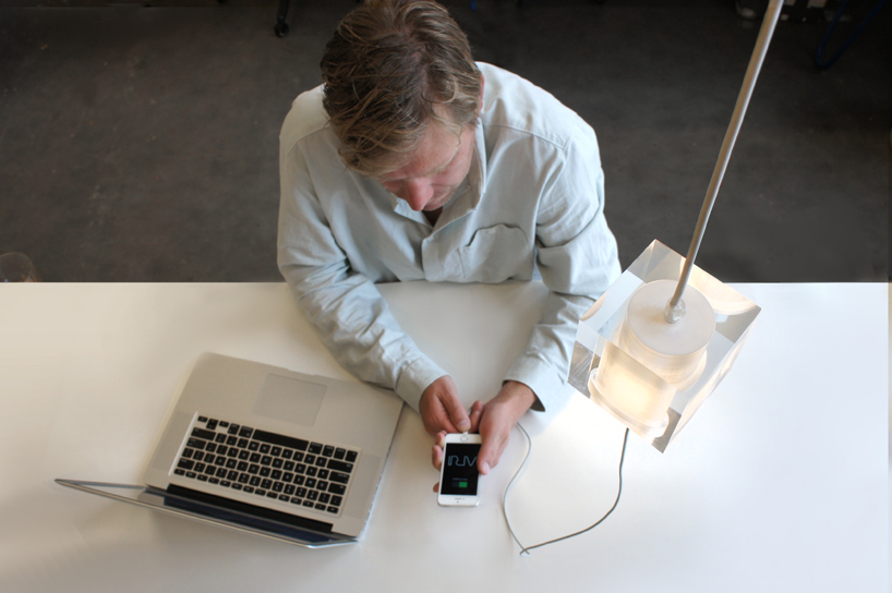 this suspending workspace lamp allows users to charge their devices simultaneously
