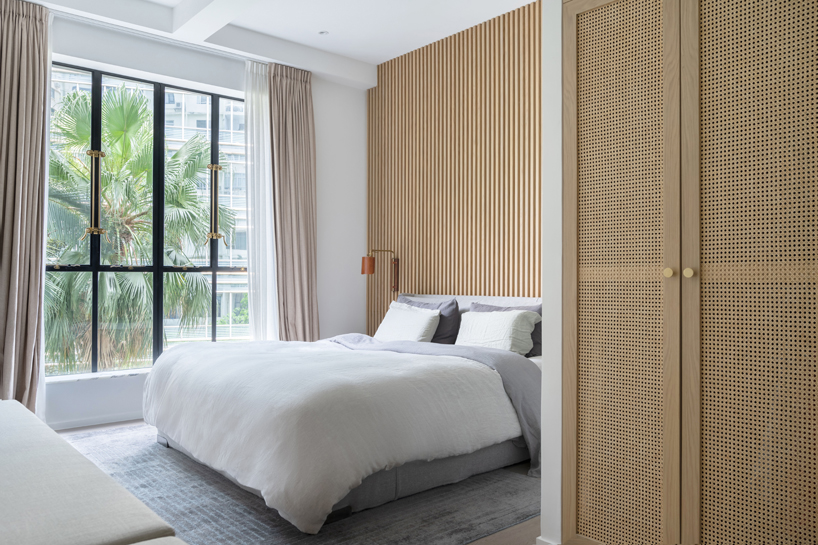 the master bedroom utilizes natural materials such as rattan and wood paired with steel and brass antique style windows to maximize the element of nature
