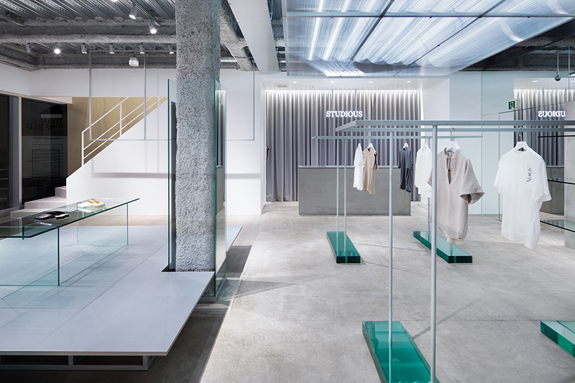 oniki adds stage with laminated glass steps within clothing store ...