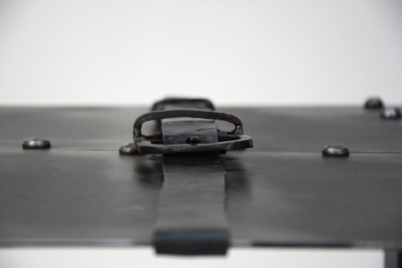 medieval inspired metal-forged table is hugged by an iron belt