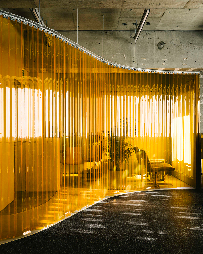 arii irie architects divides gym interiors with an orange vinyl strip curtain in tokyo