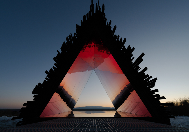 reflective red chamber emerges from prism mountain shelter’s charred wood shell