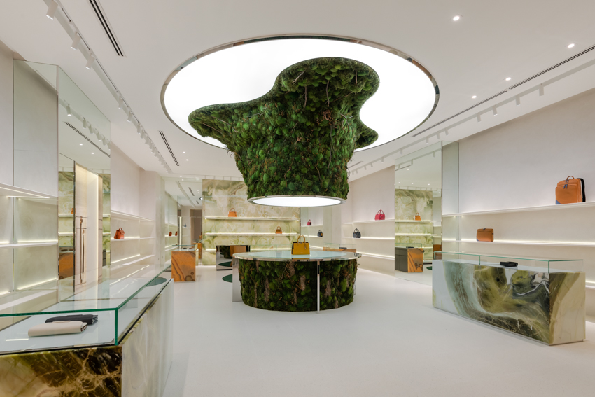 abstract tree installation sprouts from the floor to display premium leather goods