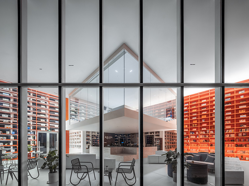 bright red bookshelves shine through glass box bookstore by wutopia lab in china