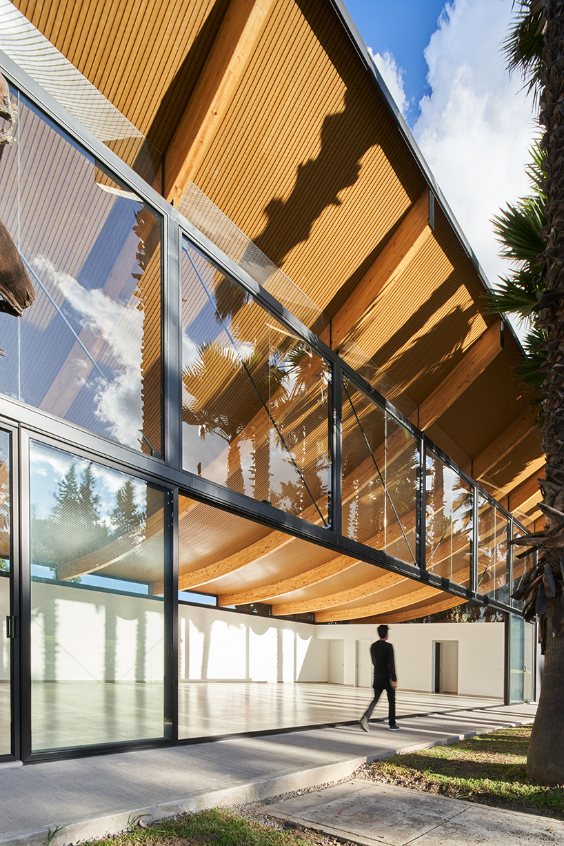 Vigas curvas de madera laminada forman un techo ligero en lo alto del Pabellón de La Coruña en Cambaia