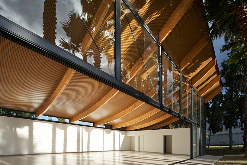 Vigas curvas de madera laminada forman un techo ligero en lo alto del Pabellón de La Coruña en Cambaia