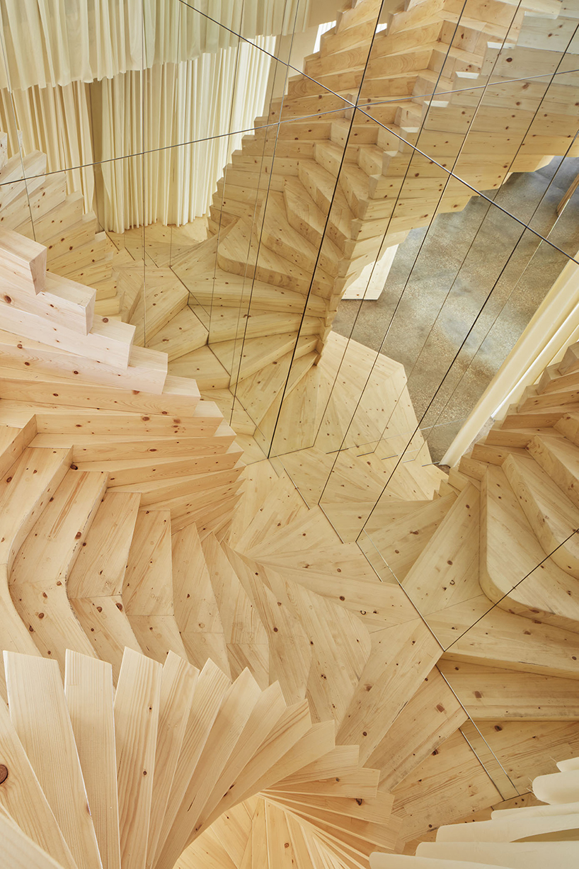 acme installs massive timber staircase with winding mirrors in its london studio