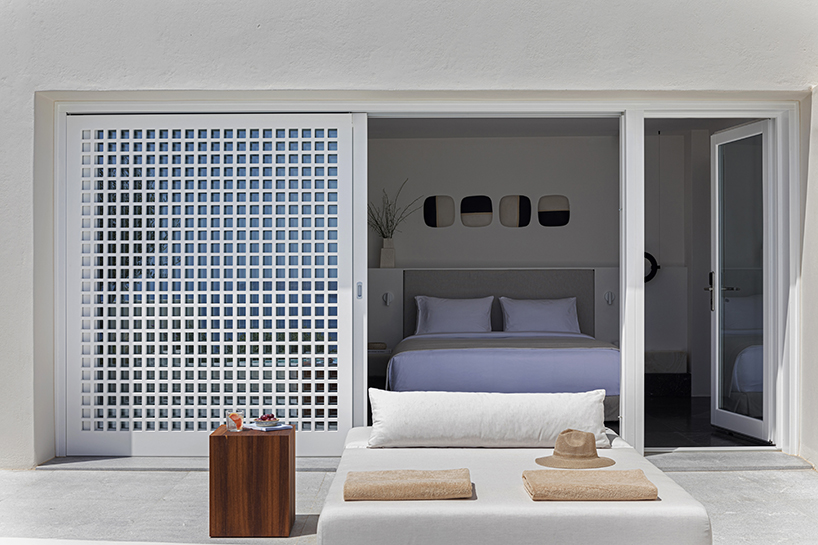 shaped like cubic prisms, kapsimalis architects' hotel rooms echo cave houses in santorini