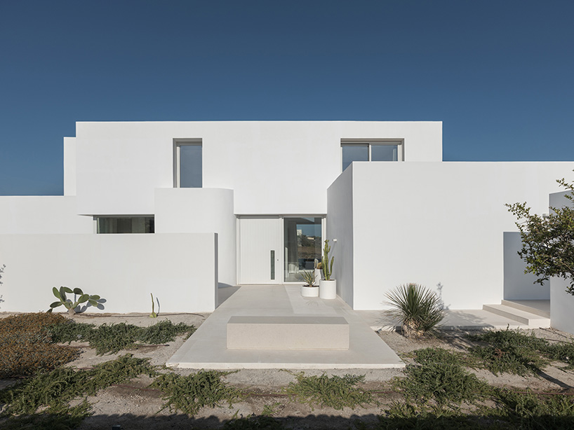 Los arquitectos de Kapsimalis incrustan el prisma blanco del paisaje volcánico griego en la casa de Oia