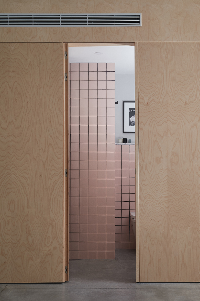 this apartment in tel aviv uses a wooden storage unit to separate private spaces