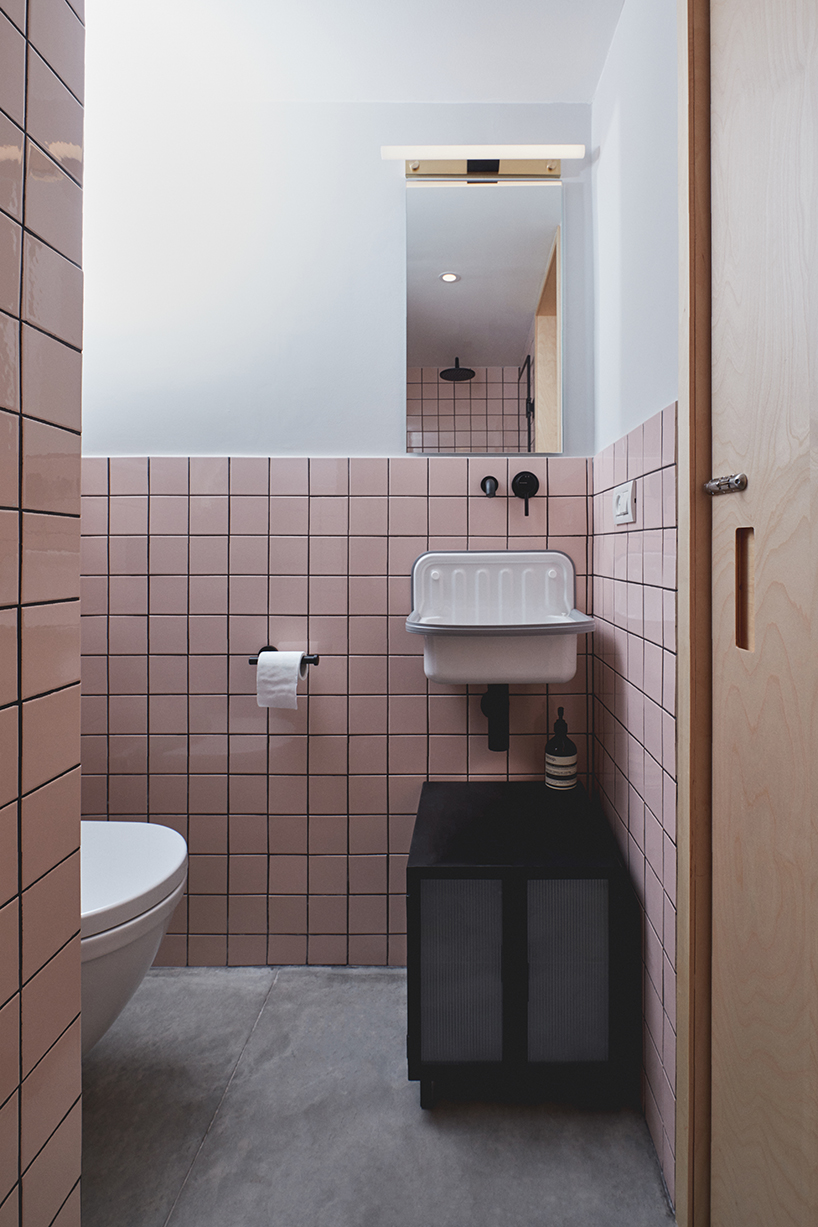 this apartment in tel aviv uses a wooden storage unit to separate private spaces