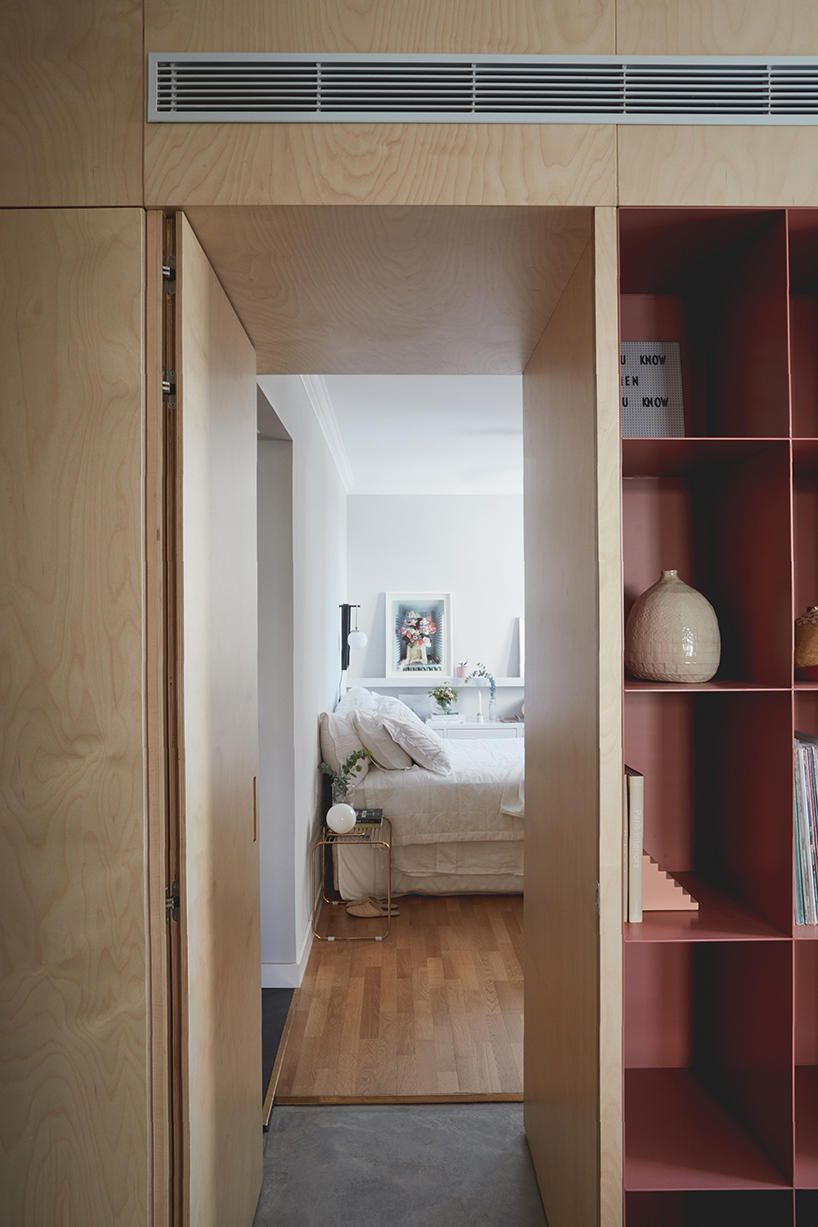 this apartment in tel aviv uses a wooden storage unit to separate private spaces