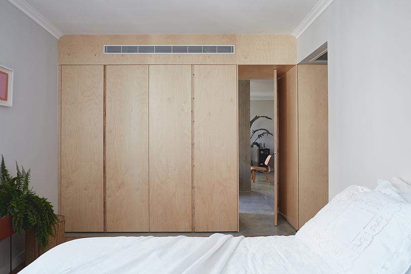 this apartment in tel aviv uses a wooden storage unit to separate private spaces