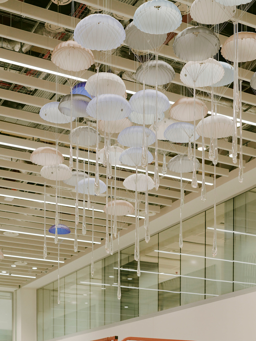 hundreds of suspended parachutes by lazerian drift above manchester airport’s terminal - 5