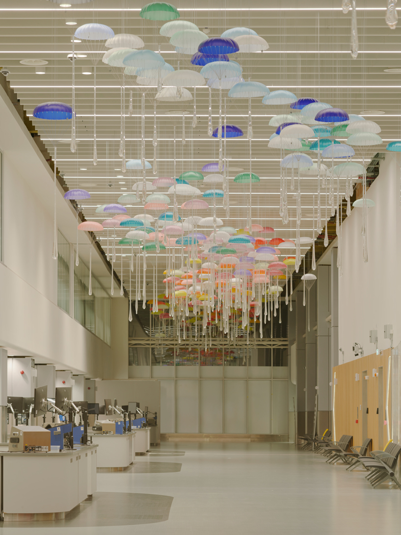 hundreds of suspended parachutes by lazerian drift above manchester airport’s terminal - 10