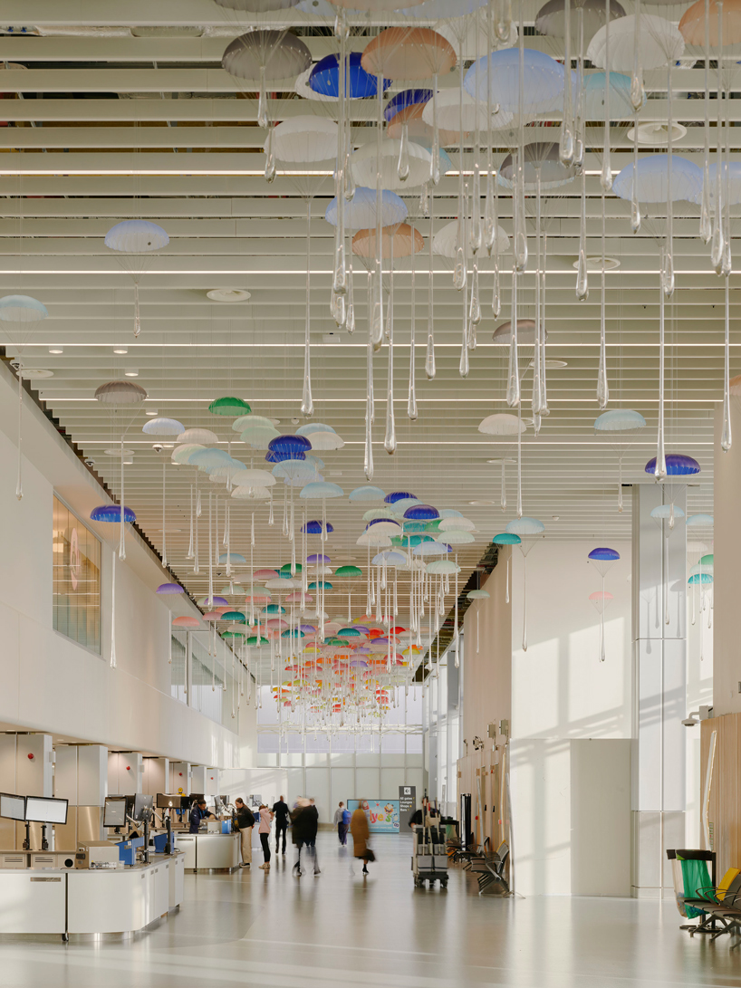 hundreds of suspended parachutes by lazerian drift above manchester airport’s terminal - 6
