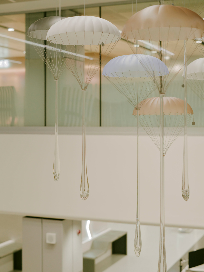 hundreds of suspended parachutes by lazerian drift above manchester airport’s terminal - 7